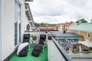 uma varanda com cadeiras e piso verde num edifício em Trosa Stadshotell & Spa em Trosa