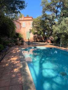 a swimming pool in front of a house at Villa la Malpagne, 400m2 les pieds dans l'eau in Rayol-Canadel-sur-Mer