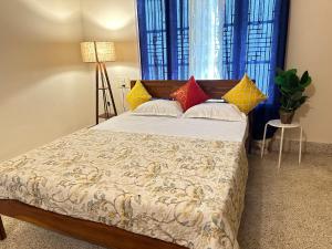 a bedroom with a bed with colorful pillows at Palace Hostel by Borrbo in Mysore