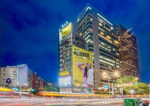 un edificio alto con un cartel en el costado en CHECK inn Taipei Xinyi en Taipéi