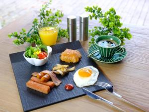 un plato de desayuno con huevos, salchichas y ensalada en Almeria Hotel en Yamanakako