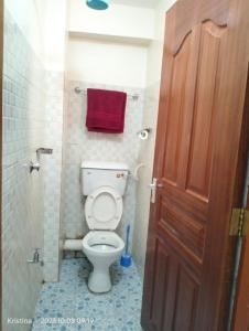 a bathroom with a toilet and a red towel at Christie's apartments Buruburu in Nairobi +2 photos