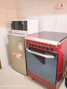 a microwave sitting on top of a red oven at Christie's apartments Buruburu in Nairobi