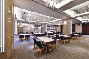 ein Speisesaal mit Tischen und Stühlen in einem Gebäude in der Unterkunft Fullon Poshtel - Linkou in Guishan