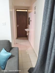 a living room with a couch and a door at Christie's apartments Buruburu in Nairobi