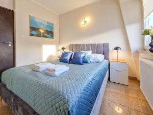 Un dormitorio con una gran cama azul con almohadas azules en Apartamenty na Wyspie - Stella Baltic - Parking, en Świnoujście