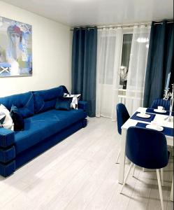 sala de estar con sofá azul y mesa en Свежая 2-комнатная квартира в центре, en Khmelʼnytsʼkyy