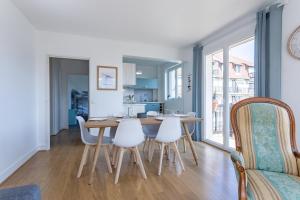 a dining room and kitchen with a table and chairs at Le Carrousel - Appartement avec studio attenant in Deauville