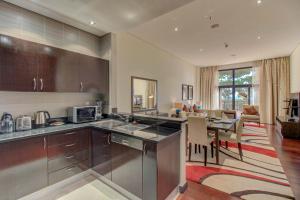 a kitchen and living room with a dining room at Luxe Getaways Royal Amwaj Palm Jumeirah Resort Apartment Holiday Home in Dubai