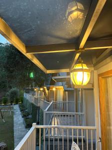 a porch with a railing and lights on a house at Kabana de Nature in Rājgarh