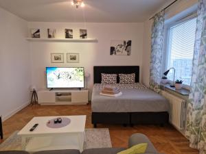 una camera con letto e TV a schermo piatto di Mysigt lägenhet a Stoccolma