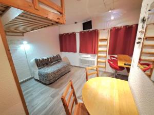 um quarto com uma mesa e uma cama e uma mesa e cadeiras em STUDIO CHALEUREUX aux pieds des pistes de ski des Glovettes em Villard-de-Lans