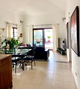 sala de estar con mesa y sofá en La Mar Poolvilla en Costa Teguise