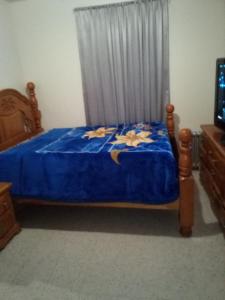 a bedroom with a bed with a blue comforter at Hunts Point Short Stays in Hunts Point