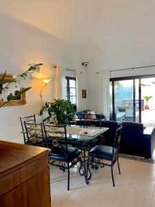 comedor y sala de estar con mesa y sillas en La Mar Poolvilla, en Costa Teguise