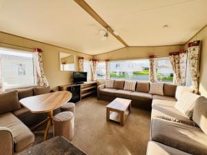 - un salon avec un canapé et une table dans l'établissement 2 Bedroom Caravan CW111, Whitecliff Bay, Bembridge, Isle of Wight, à Bembridge