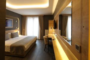 a hotel room with a bed and a desk at Hisarhan Otel in Amasya