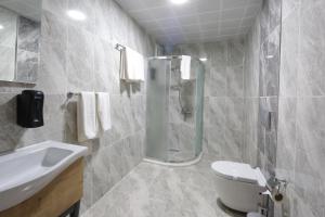 a bathroom with a shower and a sink and a toilet at Hisarhan Otel in Amasya