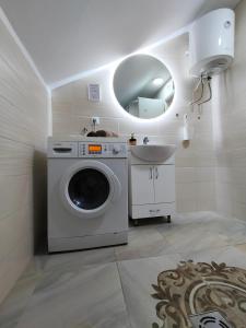 een badkamer met een wasmachine en een wastafel bij A1 - Airport Belgrade Apartment in Belgrado