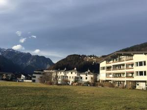 a group of buildings in a field with mountains at Ferienwohnung Spannring in Schruns-Tschagguns