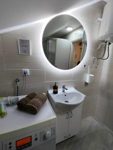 a white bathroom with a sink and a mirror at A1 - Airport Belgrade Apartment in Belgrade