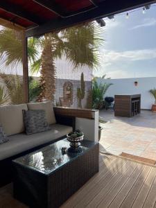 a patio with a couch and a coffee table at La Mar Poolvilla in Costa Teguise +16 photos