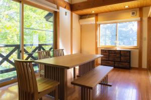 ein Esszimmer mit einem Tisch und 2 Bänken in der Unterkunft VILLA SHINANO in Shinano