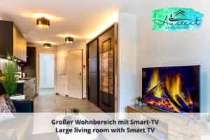 una gran sala de estar con una gran sala de estar con TV inteligente en Auszeit Apartment HARMONY am Uferpark - nur 100 m bis zum Bodensee, direkt am Bodenseeradweg, Seeblick, Sonnenbalkon, Massagesessel, schnelles WLAN, kostenloser Parkplatz, für bis zu 2 Personen, en Friedrichshafen