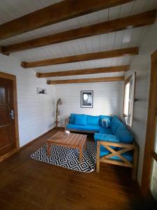 a living room with a blue couch and a table at Chalets Chomoni 