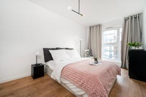 biała sypialnia z łóżkiem i oknem w obiekcie Komfortowe Apartamenty z Garażem na Milionowej w Łodzi