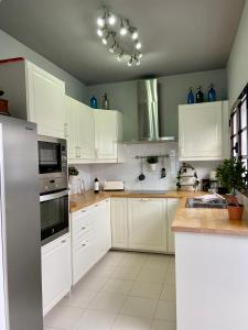 une cuisine avec des placards blancs et des vases bleus dans l'établissement La Mar Poolvilla, à Costa Teguise
