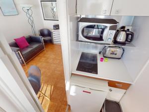 une petite cuisine avec un micro-ondes et un canapé dans l'établissement Studio climatisé avec terrasse face à la mer - FR-1-196-346, à Menton 7 autres photos