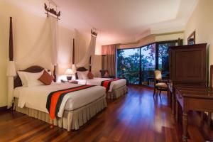 Postel nebo postele na pokoji v ubytování Angkor Palace Suite & Villa