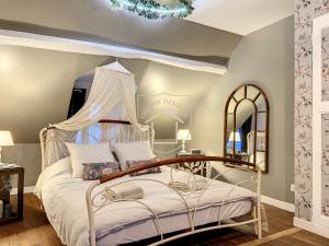 a bedroom with a canopy bed and a mirror at La Romantique des Rois # Jacuzzi # Sauna in Dourdan