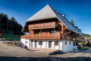 um grande edifício de madeira com uma varanda lateral em Tannenhof Fischbach - Fewo 6 "Karpfen" - Schluchsee, 2 Schlafzimmer, E-Auto Ladestation em Schluchsee