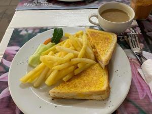 a plate with a sandwich and french fries and a cup of coffee at Maltahöhe Self Catering in Maltahöhe
