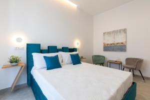 a bedroom with a blue and white bed and chairs at Baia Flegrea Meublè in Bacoli