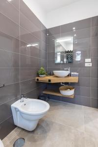 a bathroom with a white toilet and a sink at Baia Flegrea Meublè in Bacoli