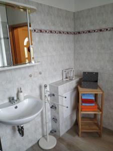 La salle de bains est pourvue d'un lavabo et d'un miroir. dans l'établissement Ferienwohnung Kijas, à Wismar