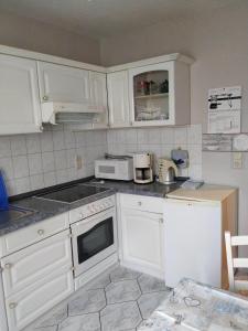 a kitchen with white cabinets and white appliances at Ferienwohnung Kijas in Wismar