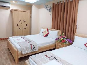 a hotel room with two beds and flowers in it at TD Luxury Hotel in Cat Ba