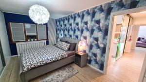 een slaapkamer met een bed en een blauwe muur bij Elisa's Place in Făgăraş