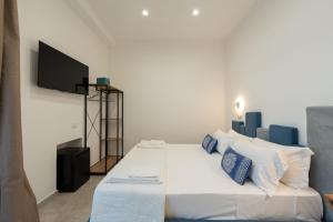 a bedroom with a bed with a tv on the wall at Baia Flegrea Meublè in Bacoli
