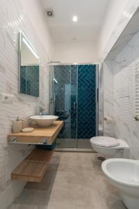a bathroom with a sink and a shower and a toilet at Baia Flegrea Meublè in Bacoli
