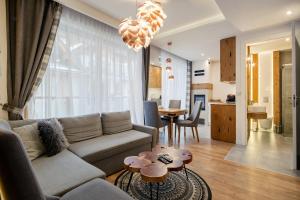 - un salon avec un canapé et une table dans l'établissement Apartament Góralska Nuta SPA Basen & Sauna, à Zakopane