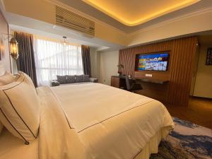 a hotel room with a bed and a flat screen tv at Bertam Resort,Penang in Kepala Batas