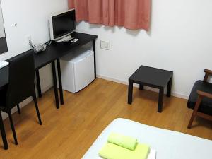 a room with a desk with a television and a bed at ホテル中央セレーネ Hotel CHUO SELENE in Osaka