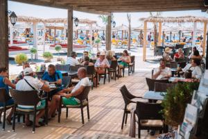 a group of people sitting at tables at an outdoor restaurant at MCM Camping in Ulcinj