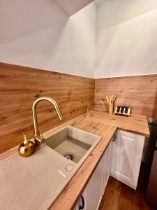 a kitchen with a sink and a wooden counter top at Apartment Gate Old Town in Zadar