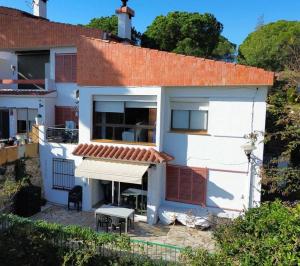 a white house with an awning in front of it at Canyelles BBQ Apartment in Lloret de Mar
